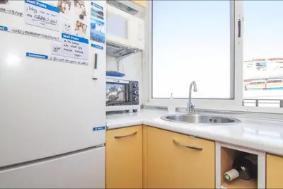 a kitchen with a white refrigerator and a sink at Terrace Duplex at Sagrada Familia by PriorityVillas in Barcelona