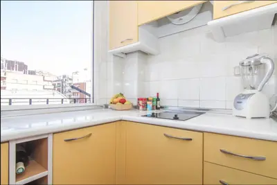 a kitchen with yellow cabinets and a sink and a window at Terrace Duplex at Sagrada Familia by PriorityVillas in Barcelona