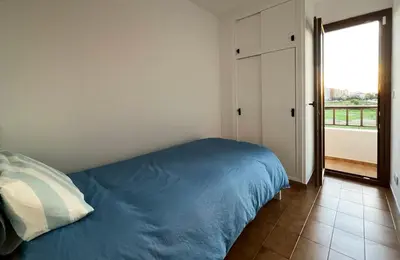 a bedroom with a blue bed and a window at Espectacular Sunny House in the beach in Cunit