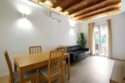 a living room with a wooden table and a couch at Stylish typical BCN flat in Barcelona