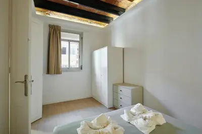 a bedroom with a bed and a dresser and a window at Stylish typical BCN flat in Barcelona