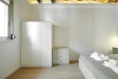 a bedroom with a white cabinet and a bed at Stylish typical BCN flat in Barcelona