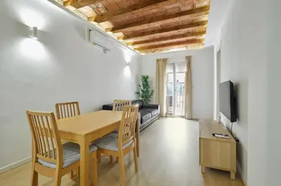 a dining room with a table and chairs and a couch at Stylish typical BCN flat in Barcelona