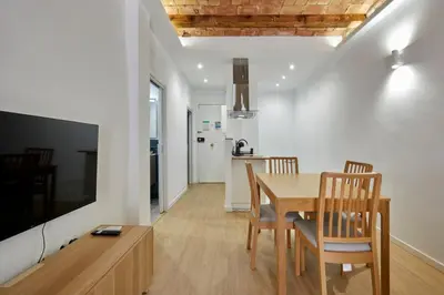 a dining room and kitchen with a table and chairs at Stylish typical BCN flat in Barcelona