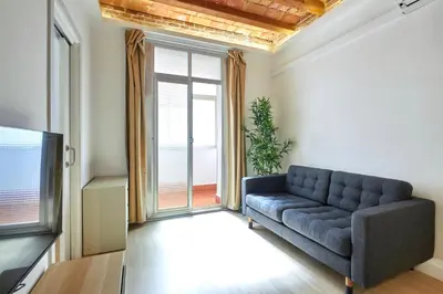 a living room with a couch and a tv at Vibrant and modern apartment in Barcelona