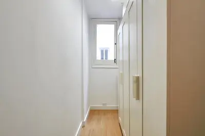 an empty hallway with a window and a door at Vibrant and modern apartment in Barcelona