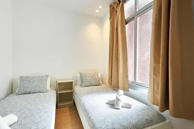 a room with two beds and a window at Vibrant and modern apartment in Barcelona