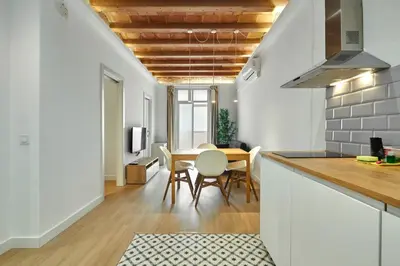 a kitchen and dining room with a table and chairs at Vibrant and modern apartment in Barcelona