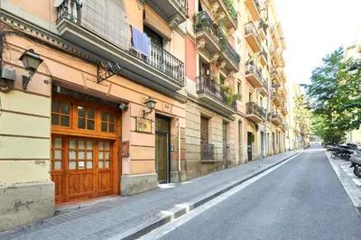 an empty street with a building with a wooden door at Vibrant and modern apartment in Barcelona