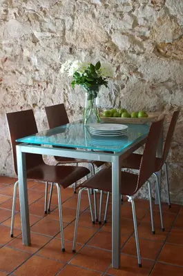 a blue table with chairs and a vase of flowers at AinB Las Ramblas-Guardia Apartments in Barcelona