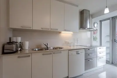 a kitchen with white cabinets and a sink at Seafront suite with terrace in Barcelona