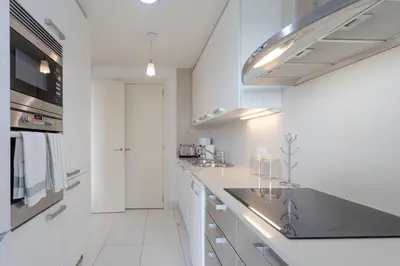 a kitchen with white cabinets and a counter top at Seafront suite with terrace in Barcelona