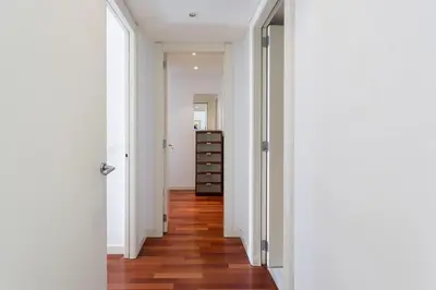 a hallway with white walls and a wooden floor at Seafront suite with terrace in Barcelona