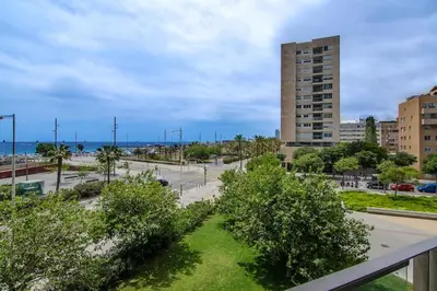 a view of a park with trees and a building at Seafront suite with terrace in Barcelona