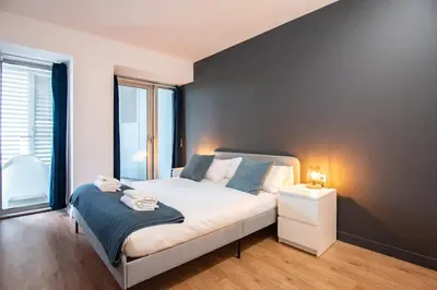 a bedroom with a bed with a blue accent wall at Seafront suite with terrace in Barcelona