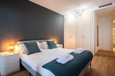 a bedroom with a large white bed with towels on it at Seafront suite with terrace in Barcelona