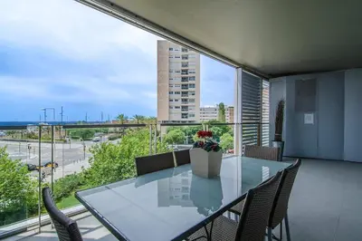 a dining room with a glass table and chairs at Seafront suite with terrace in Barcelona