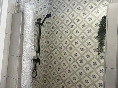 a shower in a bathroom with a tile wall at Holiday Beach Home Rincón del Mar in Cunit