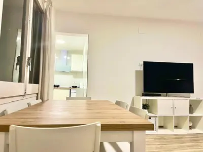 a dining room with a table and a television at Holiday Beach Home Rincón del Mar in Cunit