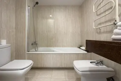 a bathroom with a tub and a toilet and a sink at The Lonely Chimney Apartments in Barcelona