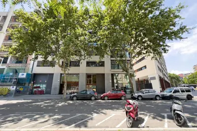 two scooters parked in a parking lot in front of a building at The Lonely Chimney Apartments in Barcelona
