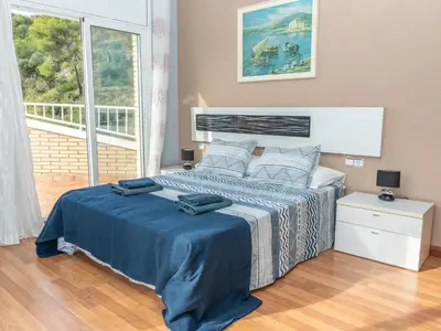 a bedroom with a bed with blue sheets and a window at Casa Serenidad: Naturaleza, Jacuzzi & Parking en Cubelles - ES-332-10 in Cubelles