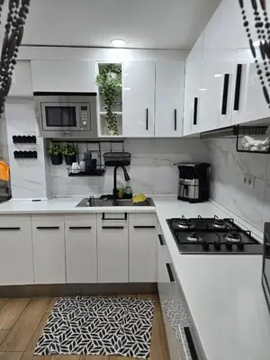 a kitchen with white cabinets and a kitchen rug at Apartamento Moderno, amplio y muy cómodo in Terrassa