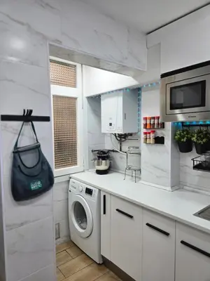 a white kitchen with a washing machine in it at Apartamento Moderno, amplio y muy cómodo in Terrassa