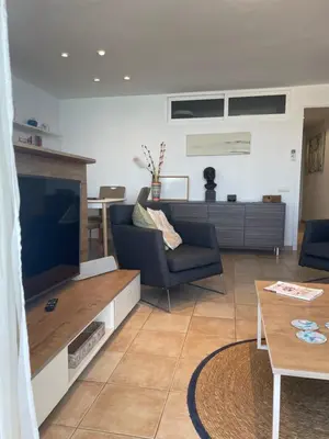 a living room with a tv and a couch and a table at Viva Sitges - Sitges View in Sitges