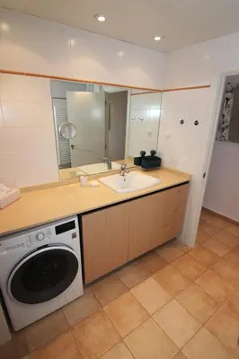 a bathroom with a sink and a washing machine at Viva Sitges - Sitges View in Sitges