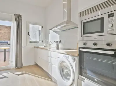 a kitchen with a washing machine and a microwave at La Terraza de Badalona in Badalona