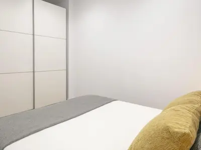 a white bedroom with a bed and a couch at La Terraza de Badalona in Badalona
