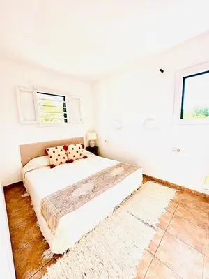 a white bedroom with a bed and a window at Solaui in Esplugues de Llobregat