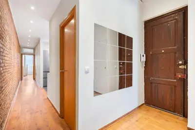 a hallway with a door and a brick wall at Lodging Apartments Entenca in Barcelona
