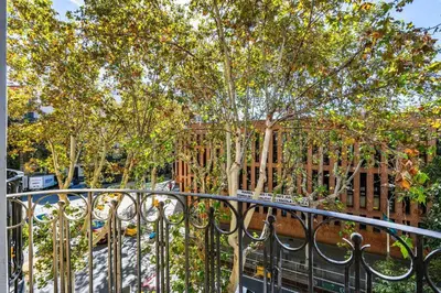 a iron fence with trees in front of a building at Lodging Apartments Entenca in Barcelona