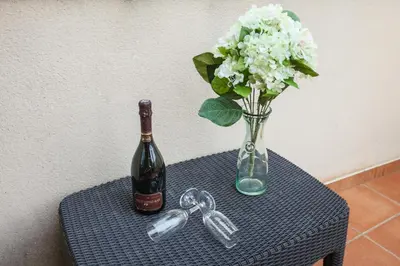 a bottle of wine and a vase of flowers on a table at Matarolux 1 in Mataró