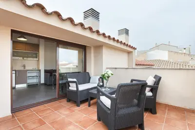 a patio with chairs and a table on a balcony at Matarolux 1 in Mataró