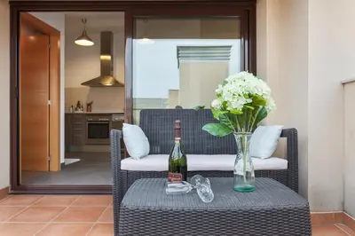 a bottle of wine and a vase of flowers on a table at Matarolux 1 in Mataró