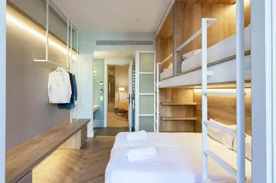a bedroom with a bunk bed and a hallway at Weflating Boutique Hostel in Barcelona