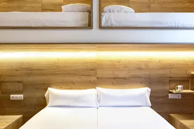 a bedroom with a bed with white pillows at Weflating Boutique Hostel in Barcelona
