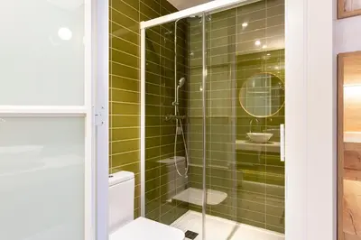 a bathroom with a shower with green tiles at Weflating Boutique Hostel in Barcelona