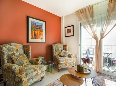 a living room with a chair and a table at Casa Rainbow by Hello Homes Sitges in Sitges