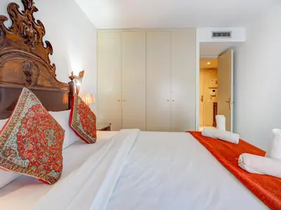 a bedroom with a large white bed with red pillows at Casa Rainbow by Hello Homes Sitges in Sitges