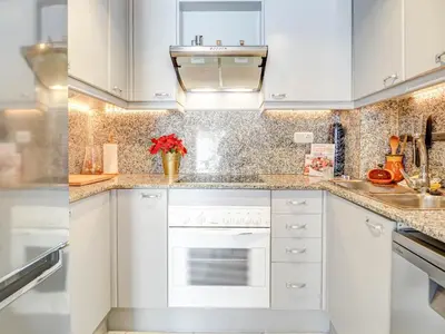 a white kitchen with white cabinets and a sink at Casa Rainbow by Hello Homes Sitges in Sitges