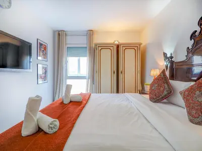 a bedroom with a large white bed with towels on it at Casa Rainbow by Hello Homes Sitges in Sitges