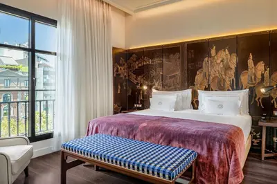 a bedroom with a large bed and a large window at Cotton House Hotel, Autograph Collection in Barcelona