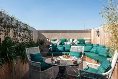 a patio with a couch and a table and chairs at Cotton House Hotel, Autograph Collection in Barcelona