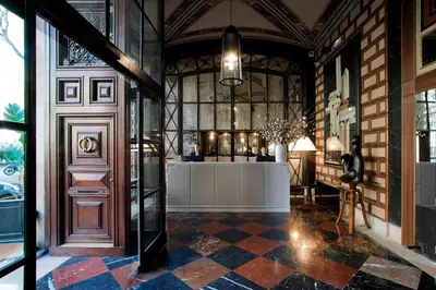 a lobby with a reception desk in a building at Cotton House Hotel, Autograph Collection in Barcelona