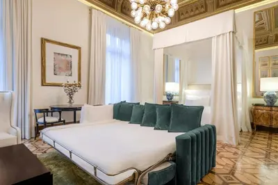 a bedroom with a large white bed with green pillows at Cotton House Hotel, Autograph Collection in Barcelona