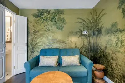 a living room with a blue couch and a table at Cotton House Hotel, Autograph Collection in Barcelona